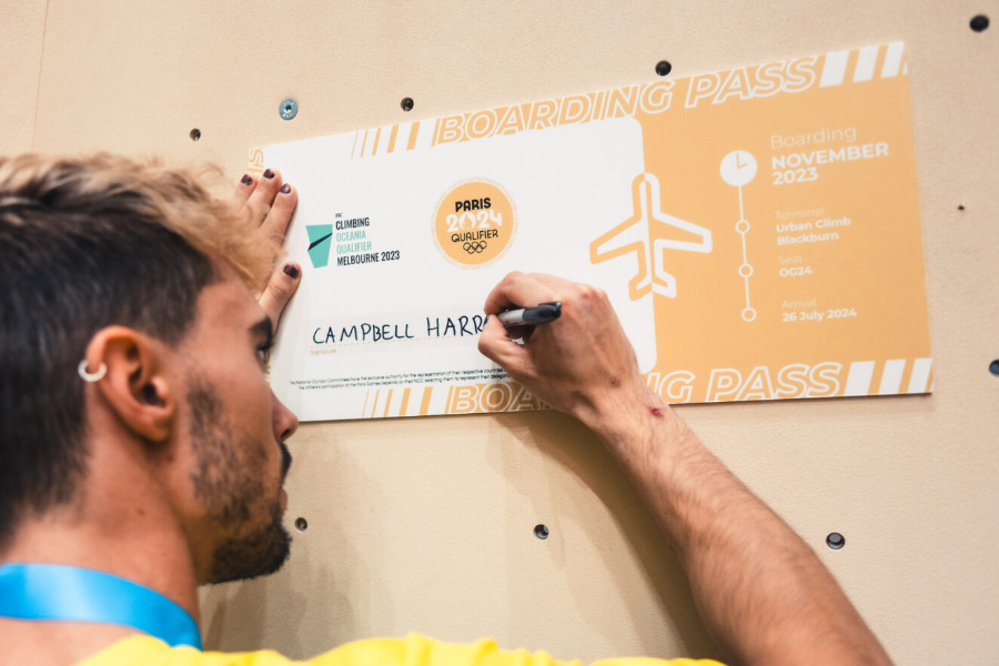 Campbell Harrison signing his "boarding pass" after qualifying for the Paris 2024 Olympics. 