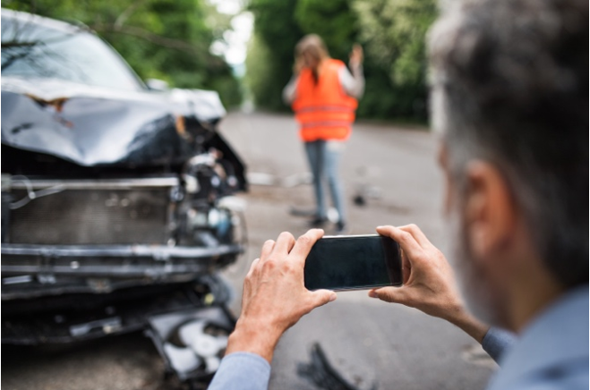 Man photographing a wrecked car