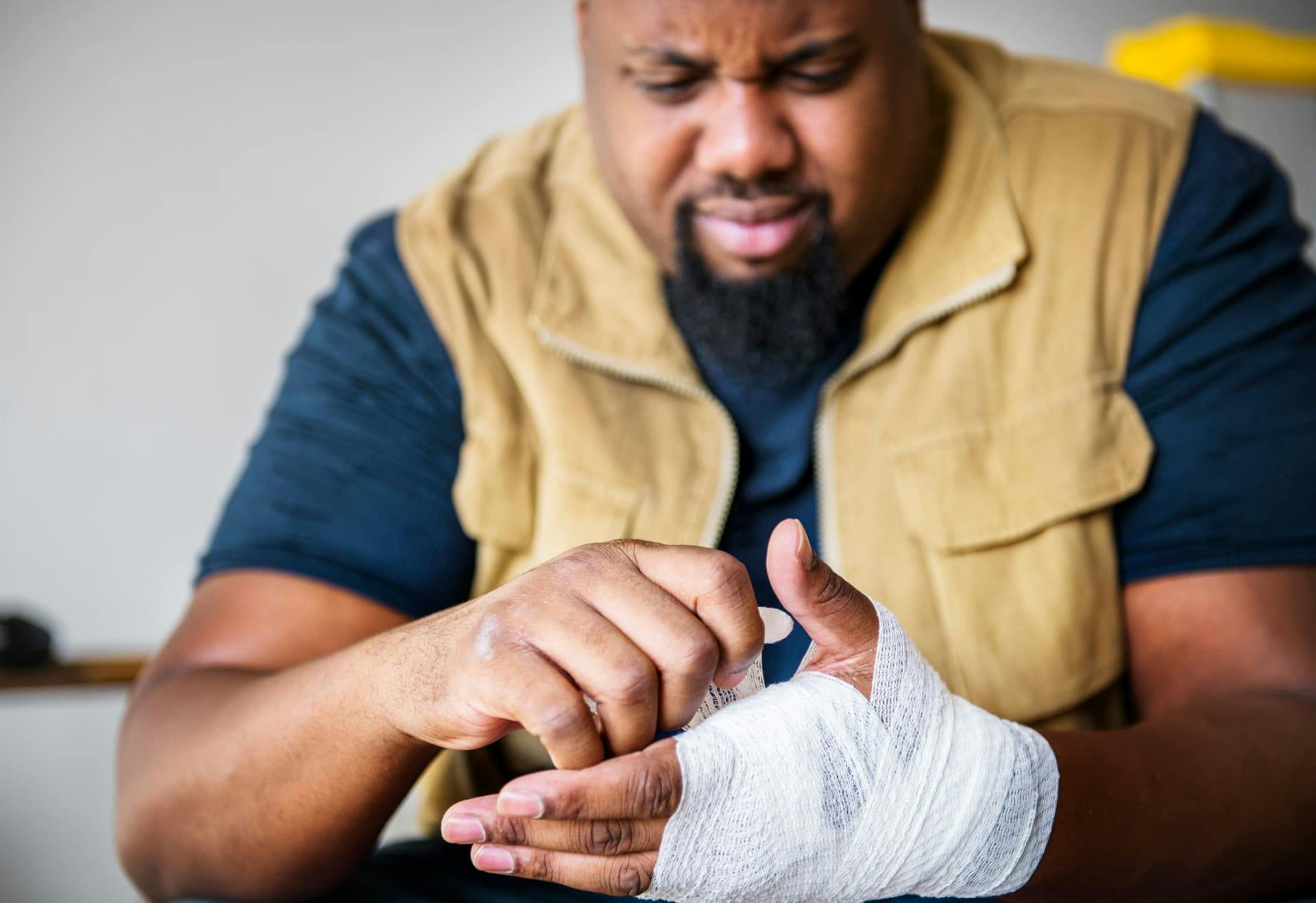 Man wrapping up his hand with gauze