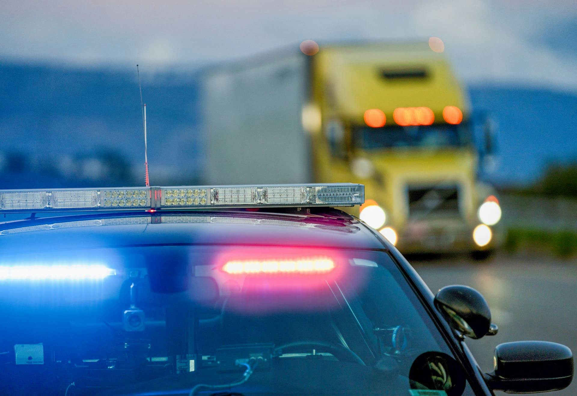 Police car with semi truck in the background