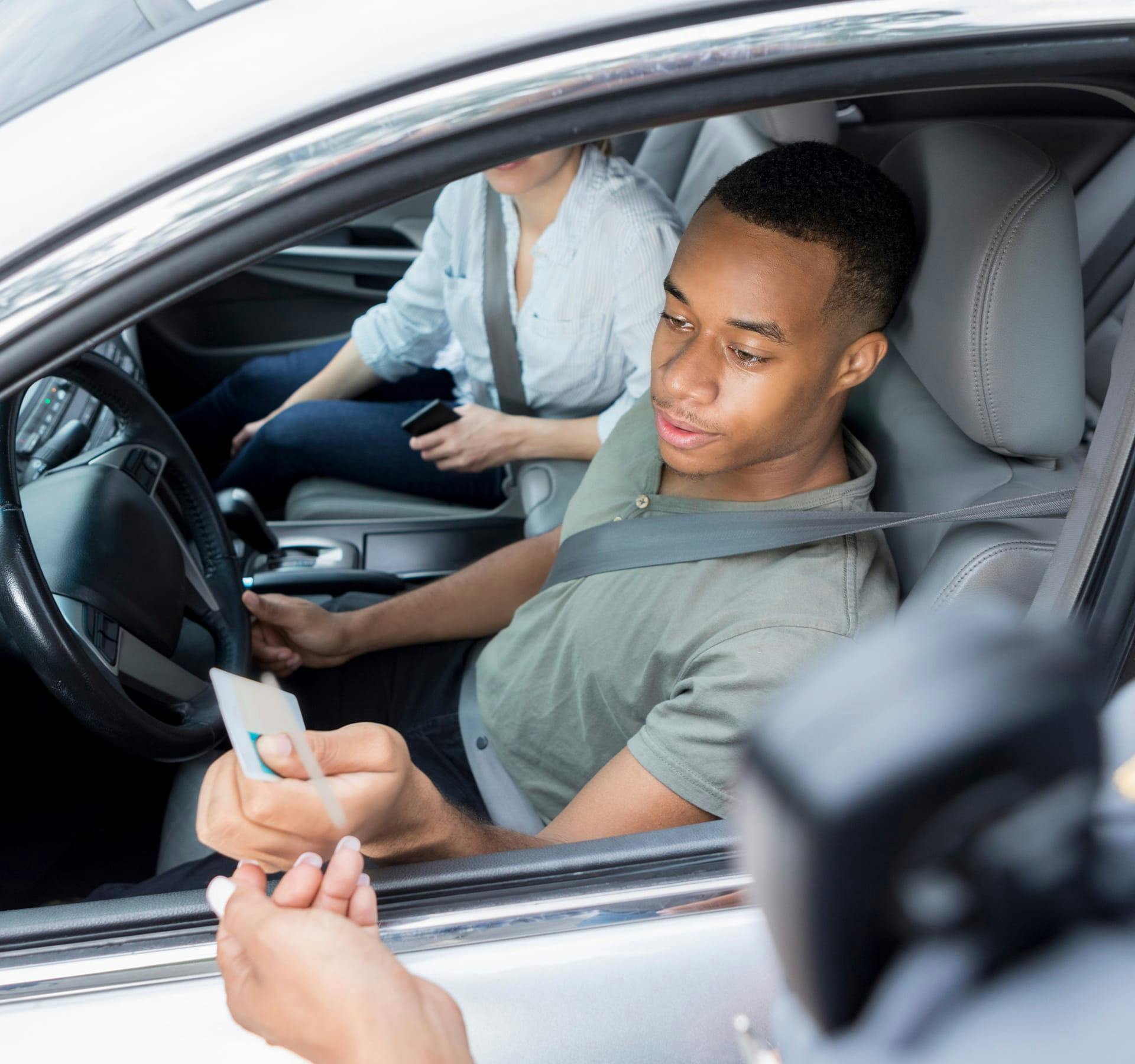 Man giving his license to a police officer