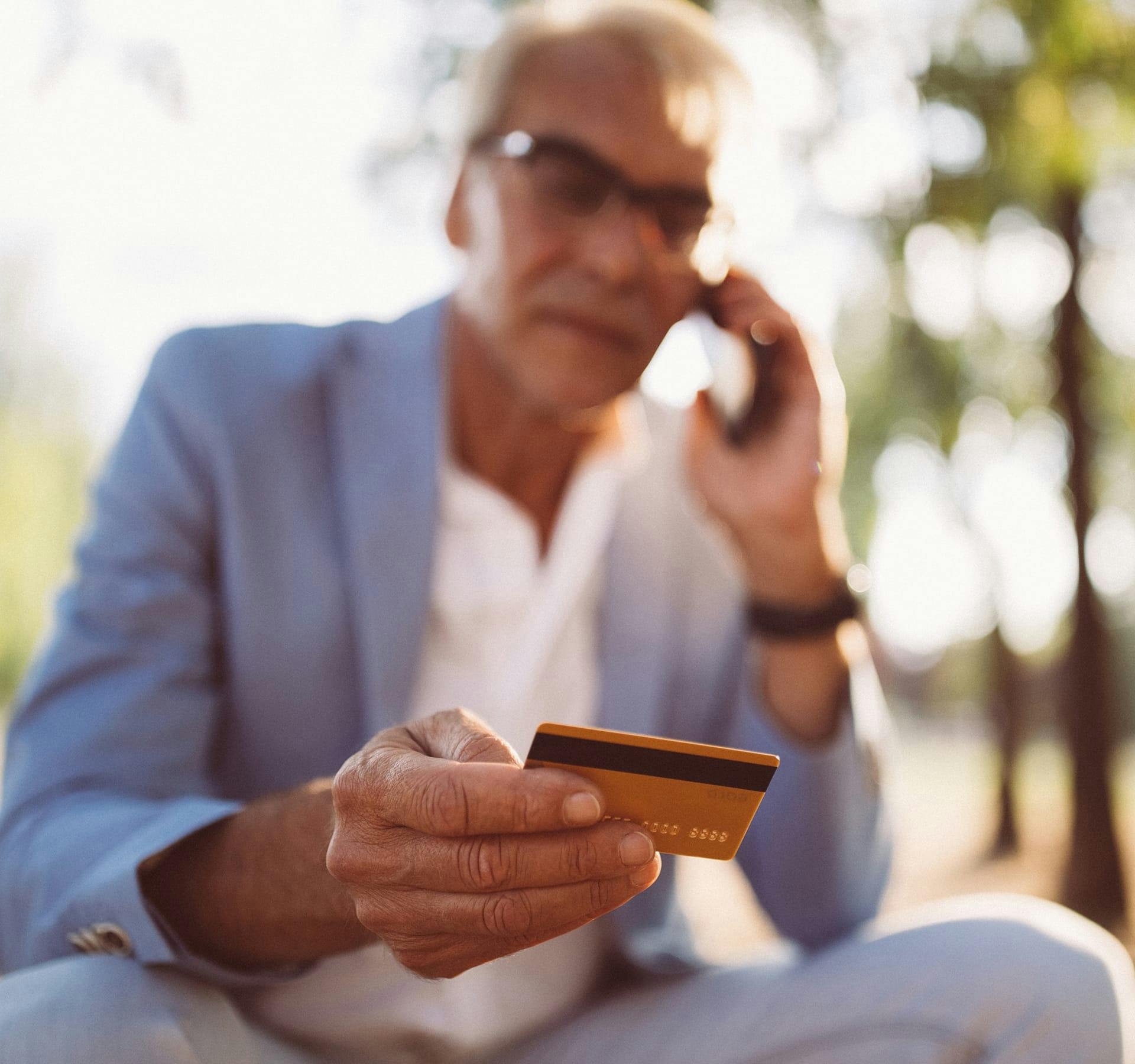 Distressed man looking at his credit card.