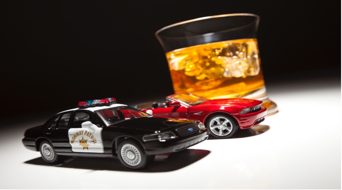 Alcohol glass next to two toy cars