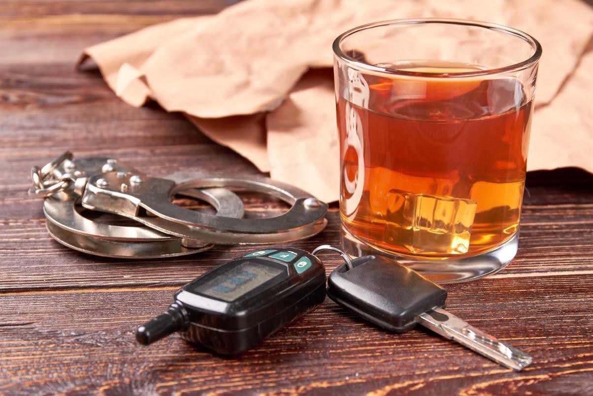 Car keys next to a glass of alcohol