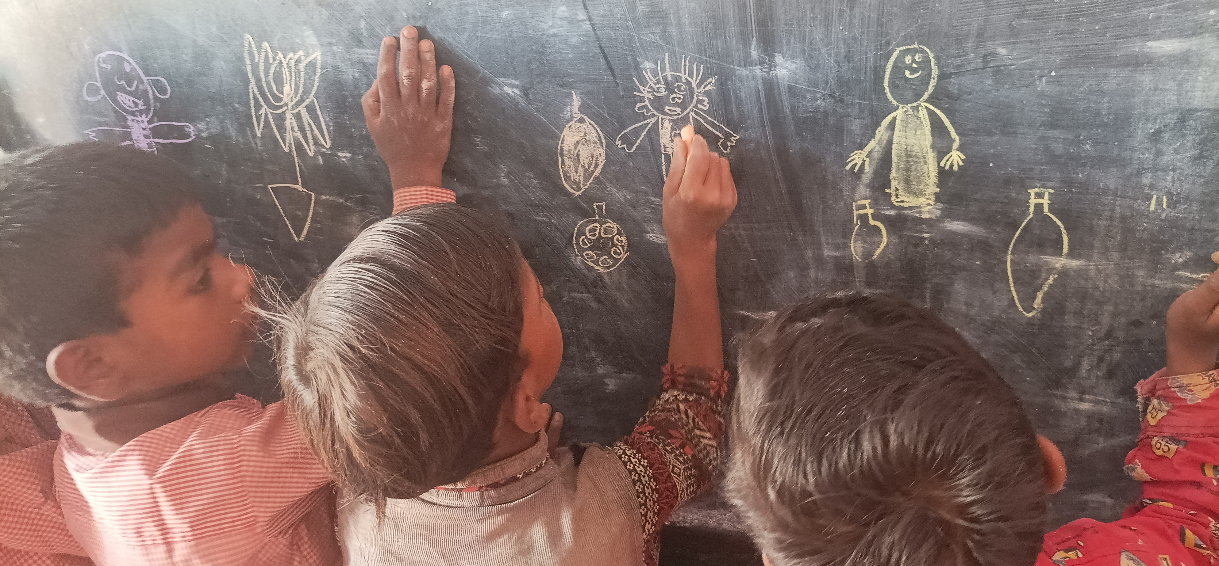 Children drawing on black board
