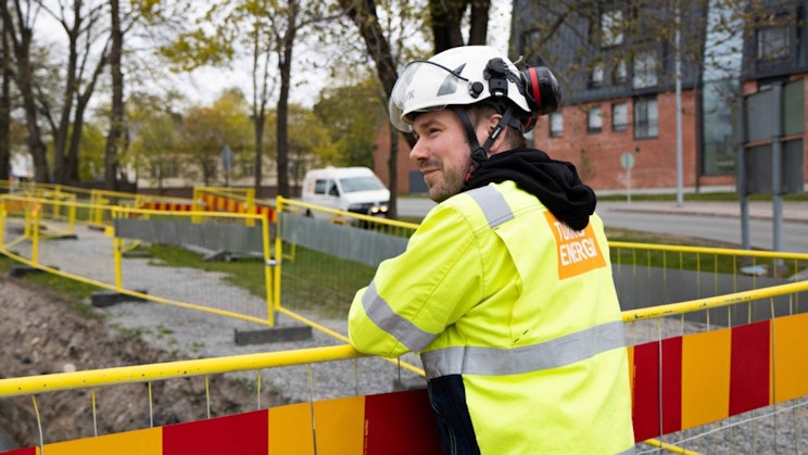 turvaliivissä oleva mies seisoo aidan vieressä