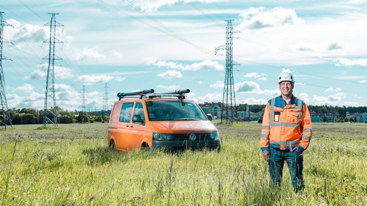 mies seisoo pakettiauton vieressä pellolla