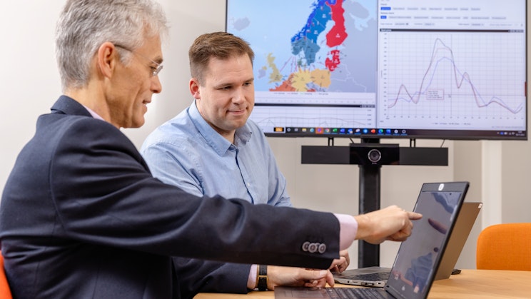 kaksi miestä katsomassa kannettavan tietokoneen näyttöä