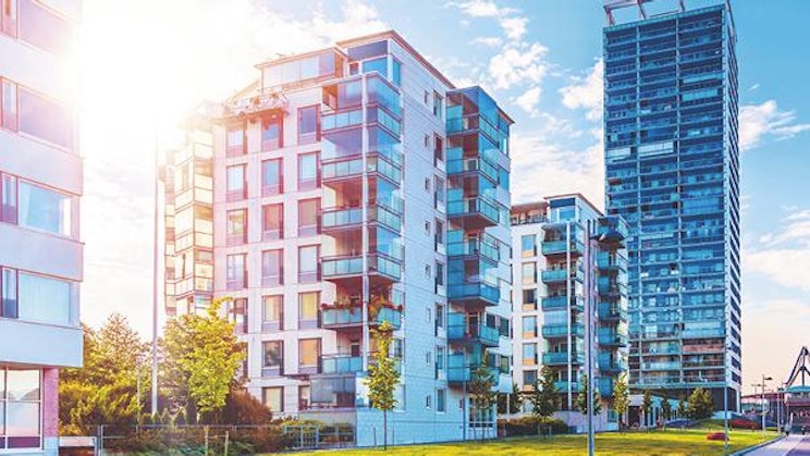 ruohoalue korkeiden rakennusten edessä