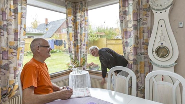 mies on pöydän ääressä ikkunan edessä