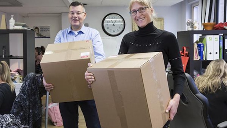 mies ja nainen pitelevät laatikoita toimistossa