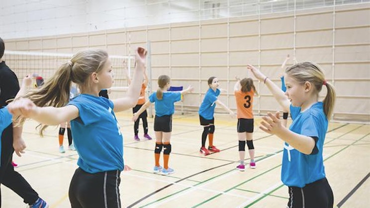 ryhmä nuoria tyttöjä pelaamassa lentopalloa