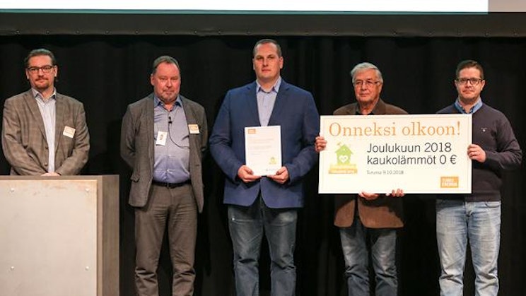 ryhmä miehiä seisomassa lavalla kylttiä pitelemässä