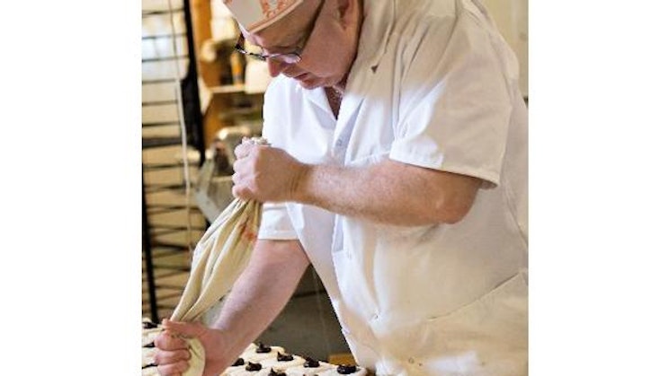 mies kokin hatussa tekee keksejä