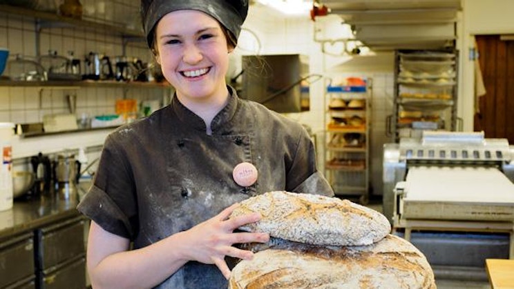 nainen keittiössä pitelemässä leipää