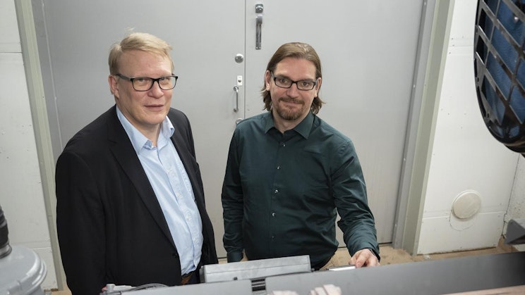 kaksi miestä seisoo vierekkäin huoneessa