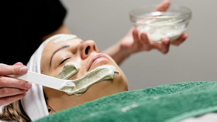 nainen saa kasvonaamion kasvoilleen