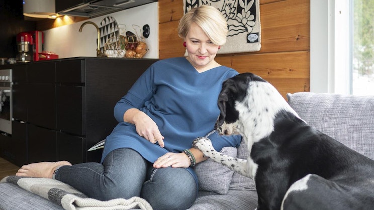 nainen on sohvalla koiran kanssa