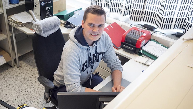 mies on työpöydän ääressä kannettavan tietokoneen kanssa