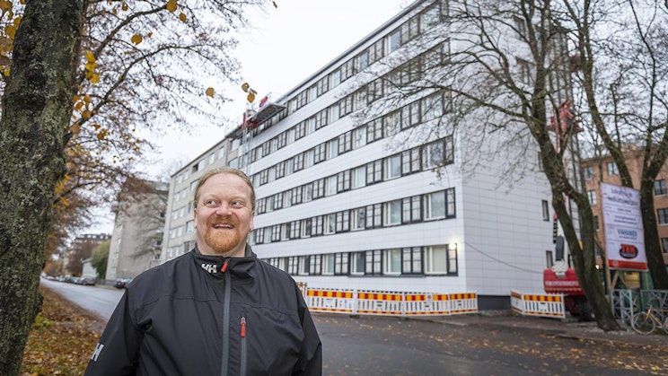 mies seisoo suuren valkoisen rakennuksen edessä