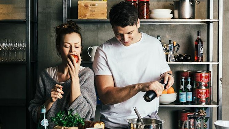 mies ja nainen valmistavat ruokaa keittiössä