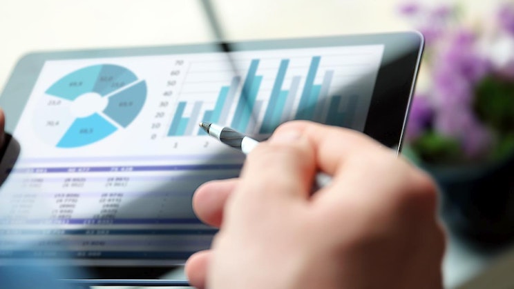 henkilö pitelee tablettia kynä kädessään