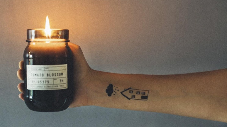 henkilö pitelee kynttilää, jossa on tarra