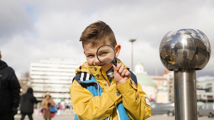 nuori poika katselee suurennuslasin läpi