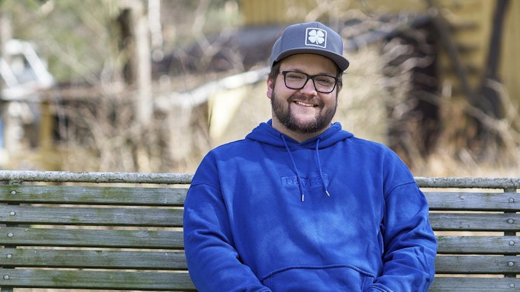 sininen huppari pukeutunut mies on puupenkillä