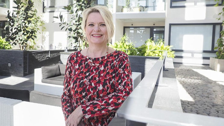 nainen punamustaisessa mekossa seisomassa parvekkeella