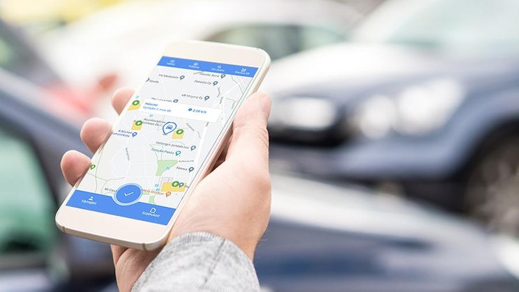 henkilö pitelee matkapuhelinta kädessään