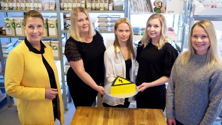 ryhmä naisia seisomassa puisen pöydän ympärillä