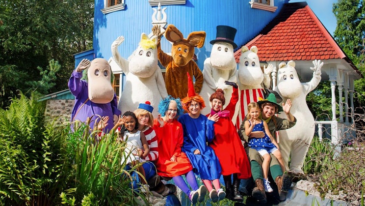 ryhmä lapsia poseeraamassa kuvassa talon edessä