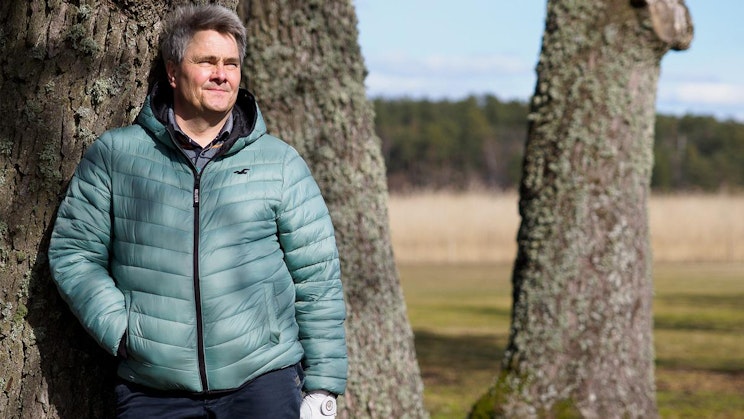 mies nojaa puuta vasten pellolla