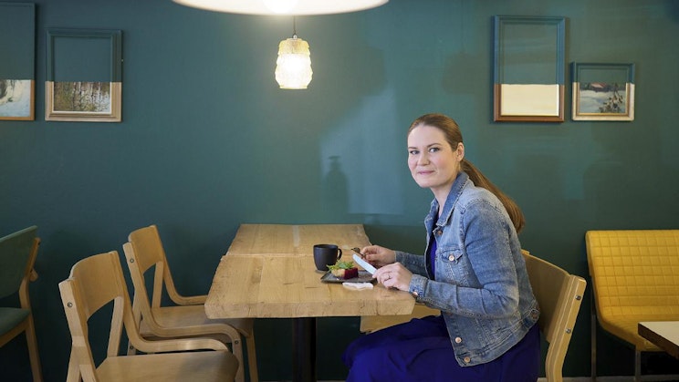 nainen on pöydän ääressä ruokalautasen kanssa