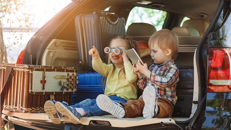 pari lasta, jotka istuvat auton takana