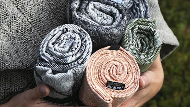 henkilö pitelee kasa pyyhkeitä käsissään