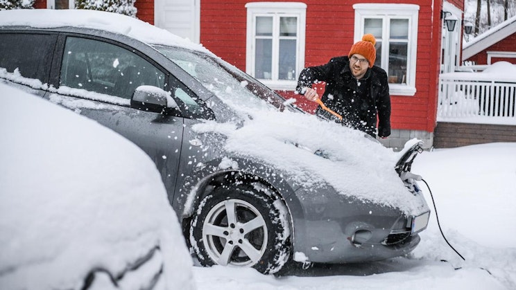 mies lapioi lunta autostaan