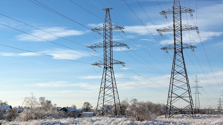 pari sähköpylvästä istumassa keskellä lumista kenttää