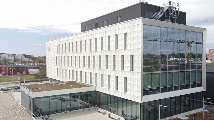 suuri valkoinen rakennus, jossa on vihreä katto