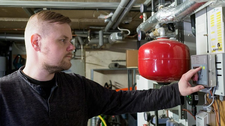 mustassa paidassa oleva mies katselee punaista esinettä