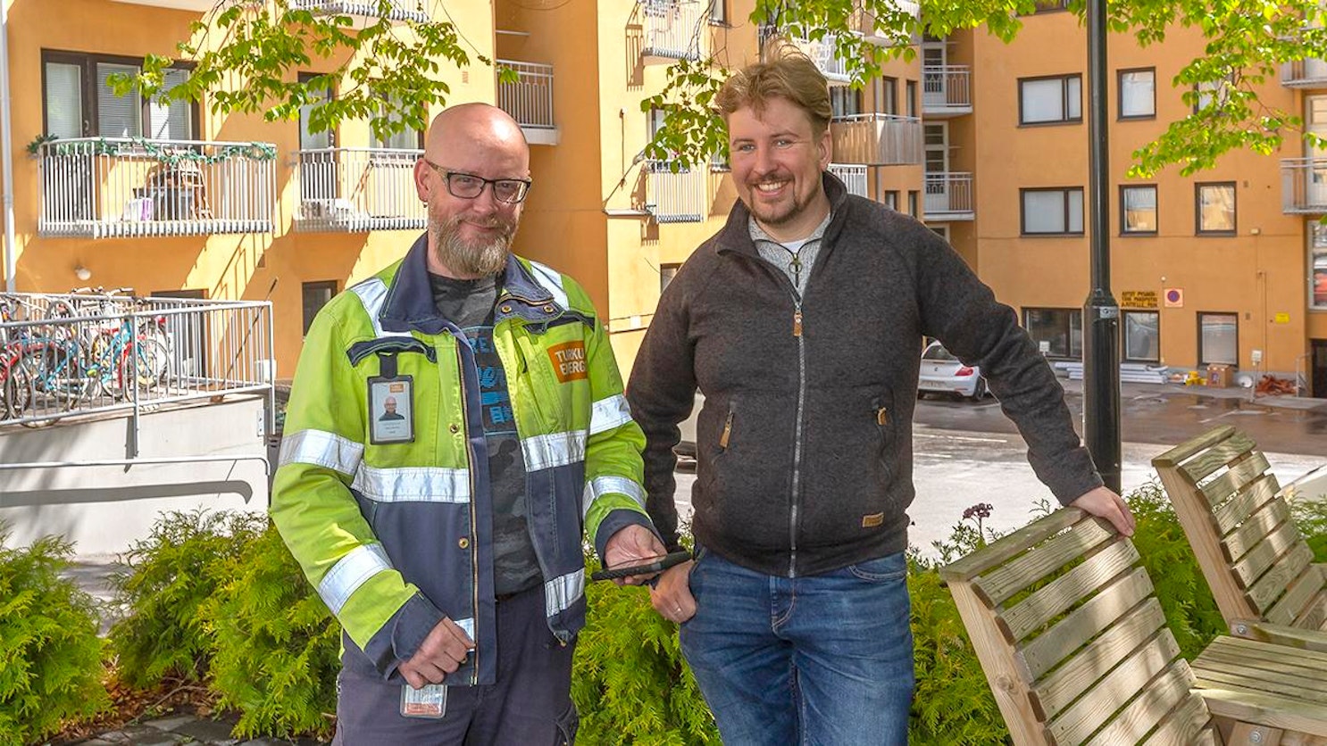 Turku Energian työnjärjestelijä Kari Kartimo ja isännöitsijä Veikko Nieminen seisovat asuinrakennuksen piha-alueella tarkastuskäynnin yhteydessä.
