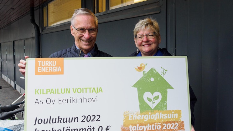 Kaksi henkilöä pitelemässä Energiafiksuin taloyhtiö 2022 -kilpailun voittokylttiä.