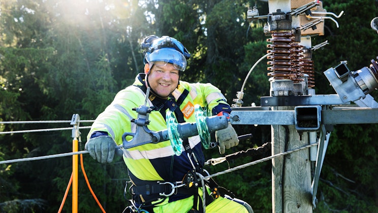 Henkilö työskentelemässä sähkölinjalla.