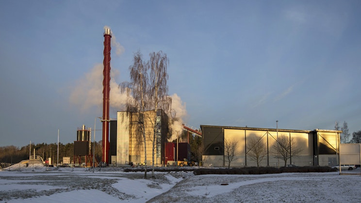 Tehdas, jonka savupiipusta tulee savua.