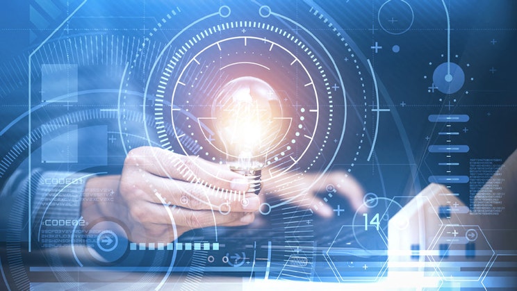 Henkilö pitää hehkulamppua kädessään. Kuvan päällä on erilaisia ohjelmistosymboleita.