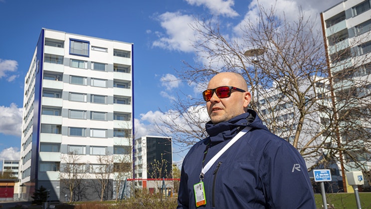 mies seisoo korkean rakennuksen edessä