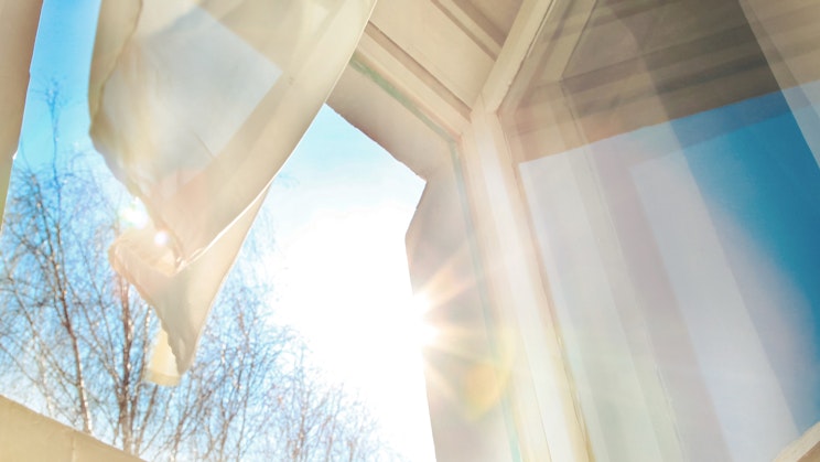 Aurinko paistaa auki olevasta ikkunasta sisään.