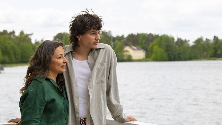 Pari ihmistä seisomassa veden äärellä. Katse sivuun.