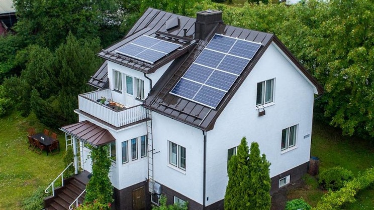 an aerial view of a house with a solar panel on the roof